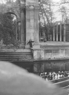 Archiwalne zdjęcie przedstawiające kobietę stojącą pod kolumną Amfiteatru.