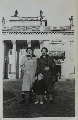 Dwie kobiety z dzieckiem stoją przed Pałacem na Wyspie.