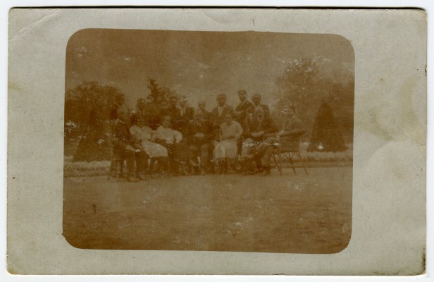 Archiwalna fotografia przedstawiająca grupę osób pozujących do zdjęcia.