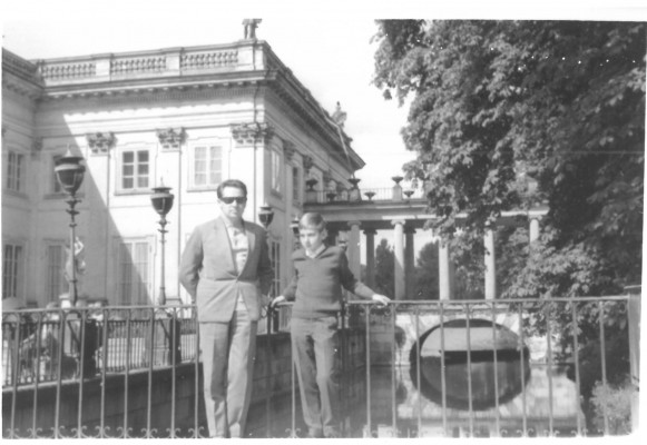 Mężczyzna i chłopiec stoją przed Pałacem na Wyspie.