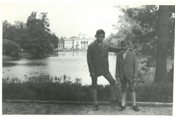 Dwaj chłopcy stojący na ścieżce przy stawie, w tle widać Pałac na Wyspie.