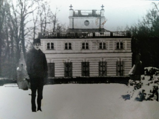 Kobieta stojąca zimą przed Białym Domem w Łazienkach Królewskich. 