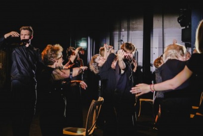 Grupa osób tańczy na scenie.