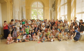 Grupa kilkudziesięciu dzieci pozuje do zdjęcia w Starej Oranżerii.