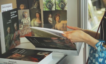Widoczna jest kobieca ręka przeglądająca książkę.