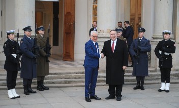 Szefowie dyplomacji Polski i USA przed Pałacem na Wyspie, za nimi stoją dwaj żołnierze z warty honorowej.