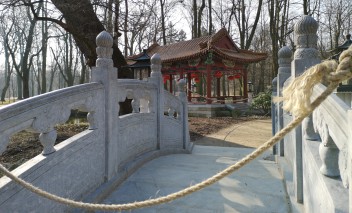 Mostek chiński przewiązany liną, w tle widoczna jest chińska altana.