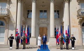Prezydent Słowacji Zuzanna Čaputová i premier Mateusz Morawiecki stoją przed Pałacem na Wyspie, ściskając sobie dłonie, po lewej i prawej stronie warta honorowa.