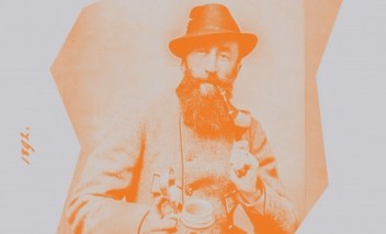 Archiwalne zdjęcie przedstawiające mężczyznę w kapeluszu, palącego fajkę.