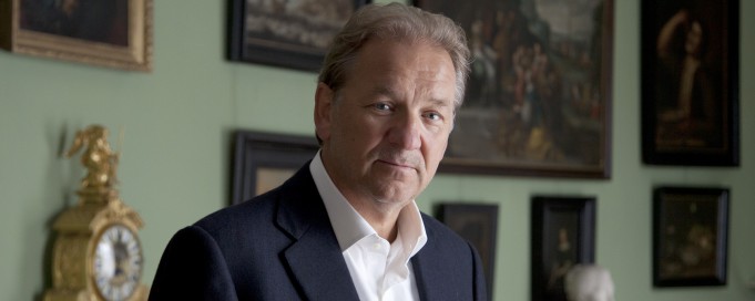 Zdjęcie dyrektora Tadeusza Zielniewicza na tle obrazów.