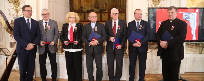 Kobieta i czterech mężczyzn stoją pod ścianą Sali Balowej Pałacu na Wyspie, w rękach trzymają teczki.