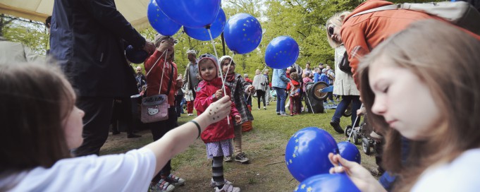 Dzieci na pikniku z niebieskimi balonami.