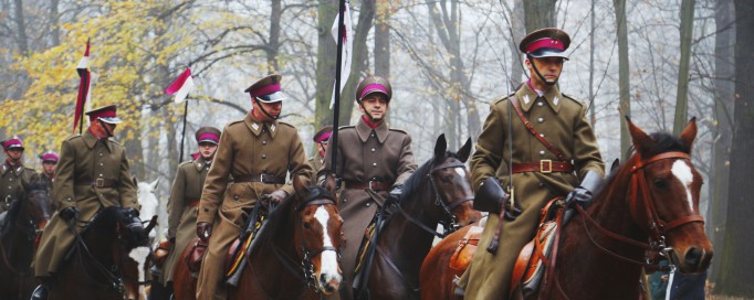 Kawalerzyści jadący na koniach w ogrodach Muzem Łazienki Królewskie.