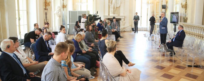 Konferencja w Sali Balowej Pałacu na Wyspie, ludzie siedzą na krzesłach, prelegenci przemawiają, stojąc przed mikrofonem.