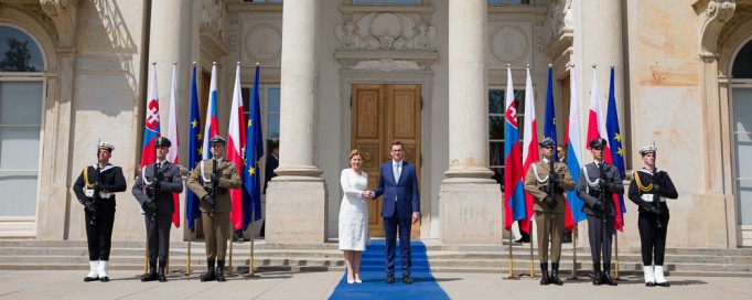 Prezydent Słowacji Zuzanna Čaputová i premier Mateusz Morawiecki stoją przed Pałacem na Wyspie, ściskając sobie dłonie, po lewej i prawej stronie warta honorowa.