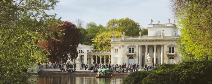 Pałac na Wyspie w otoczniu wody i drzew.