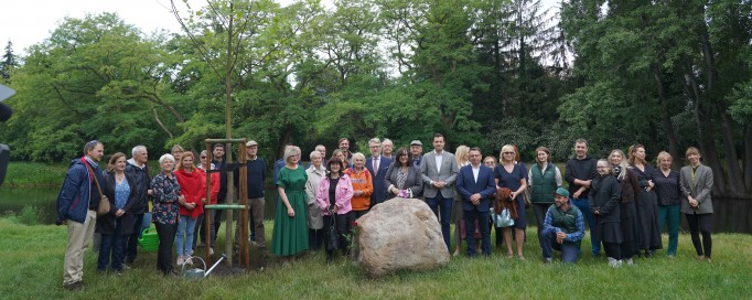 Grupa ludzi stoi w parku i pozuje do zdjęcia.