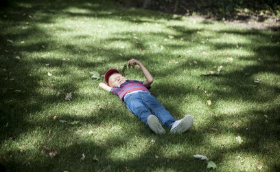 Chłopiec leżący na trawie. 