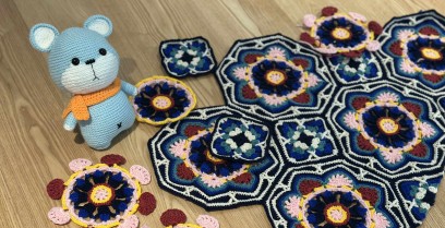 Po lewej stronie stoi niebieska zabawka - miś, obok niej leżą kolorowe serwetki.