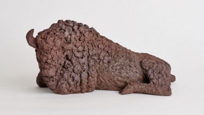 Rzeźba z gliny przedstawiająca leżącego żubra. 