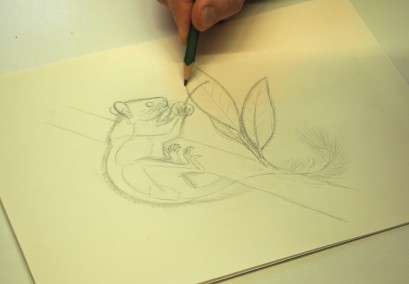 Ręka trzymająca w ręku ołówek i rysująca na kartce mysz. 