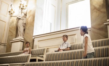 Troje dzieci na widowni Teatru Królewskiego w Starej Oranżerii.