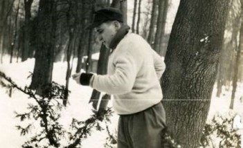 Mężczyzna stoi na śniegu w parku i ćwiczy. 